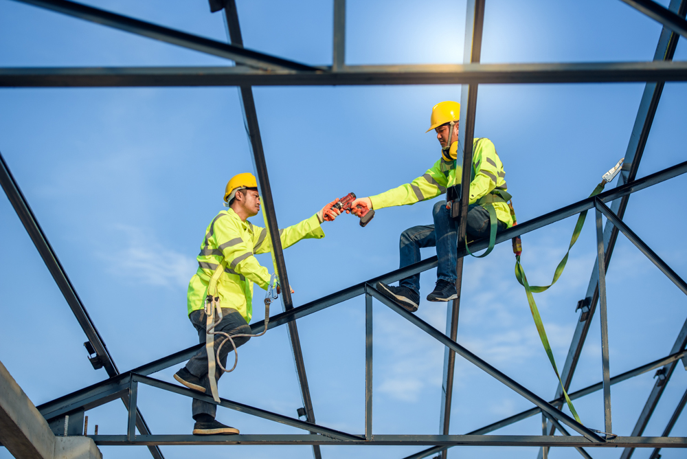 Two men wearing PPE to protect them from falling and ensure they work safely at heights